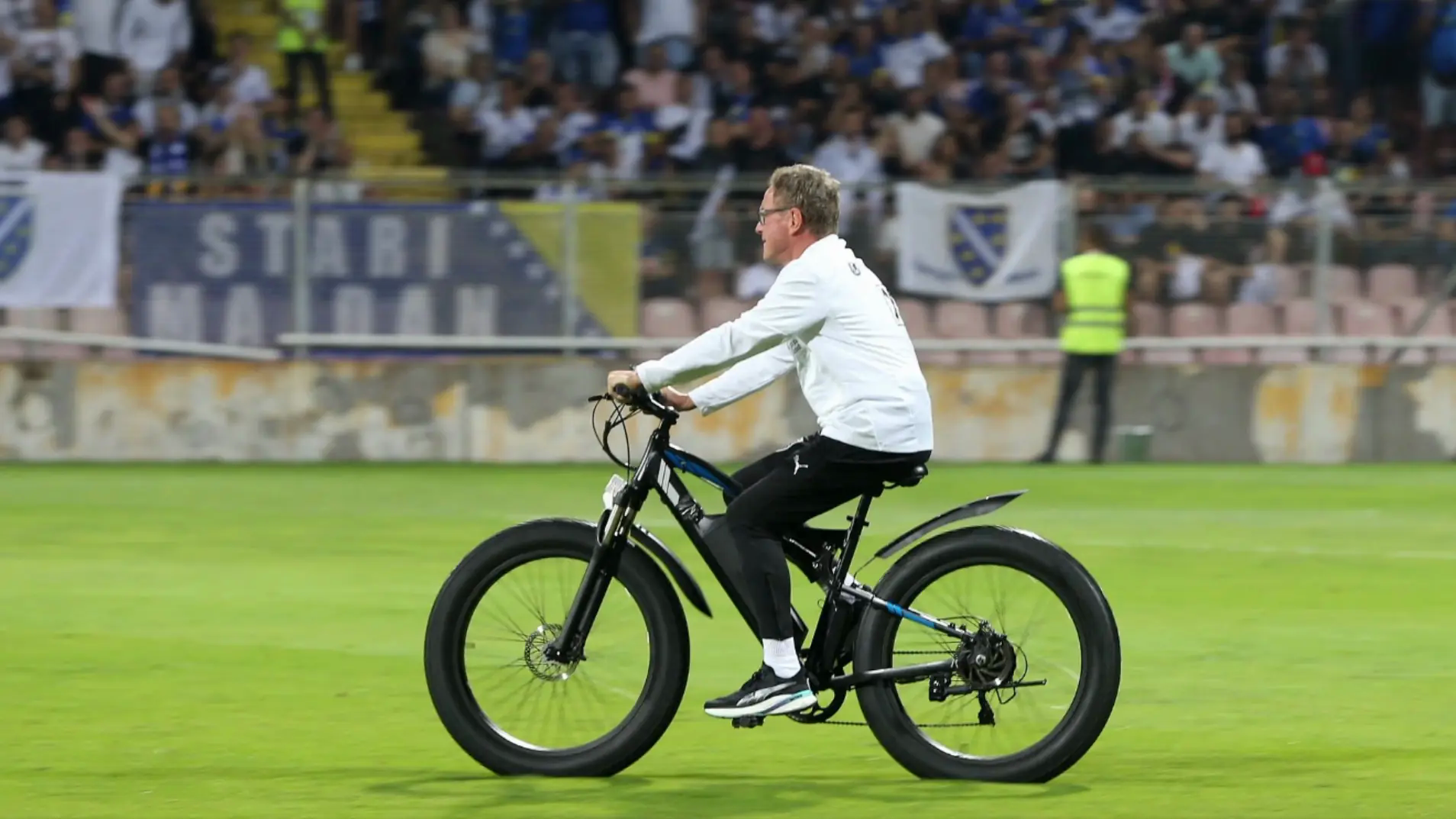 Cựu HLV Man United Ralf Rangnick đạp xe băng qua mặt s&acirc;n cỏ