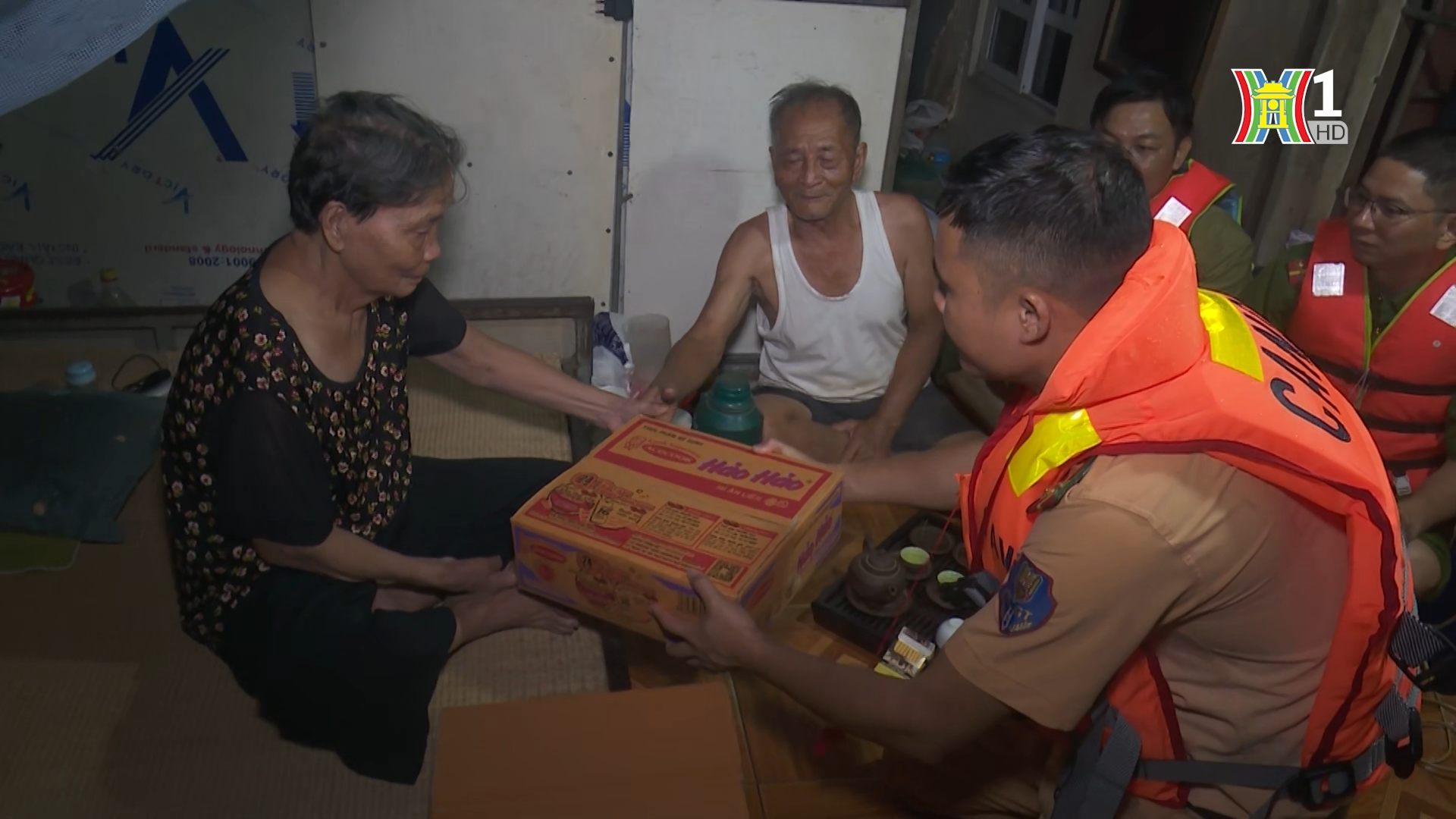 Lực lượng CSGT hỗ trợ lương thực cho người d&acirc;n tại c&aacute;c l&agrave;ng ch&agrave;i ven s&ocirc;ng Hồng.