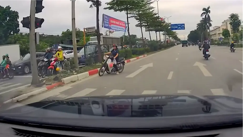 Nguy hiểm người phụ nữ tạt đầu ô tô để vượt đèn đỏ