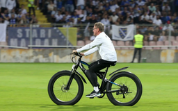 Cựu HLV Man United Ralf Rangnick đạp xe băng qua mặt sân cỏ