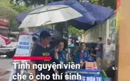 Tình nguyện viên che ô cho thí sinh giữa trời mưa