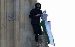 Một người đàn ông cầm cờ Palestine trèo lên tháp Big Ben